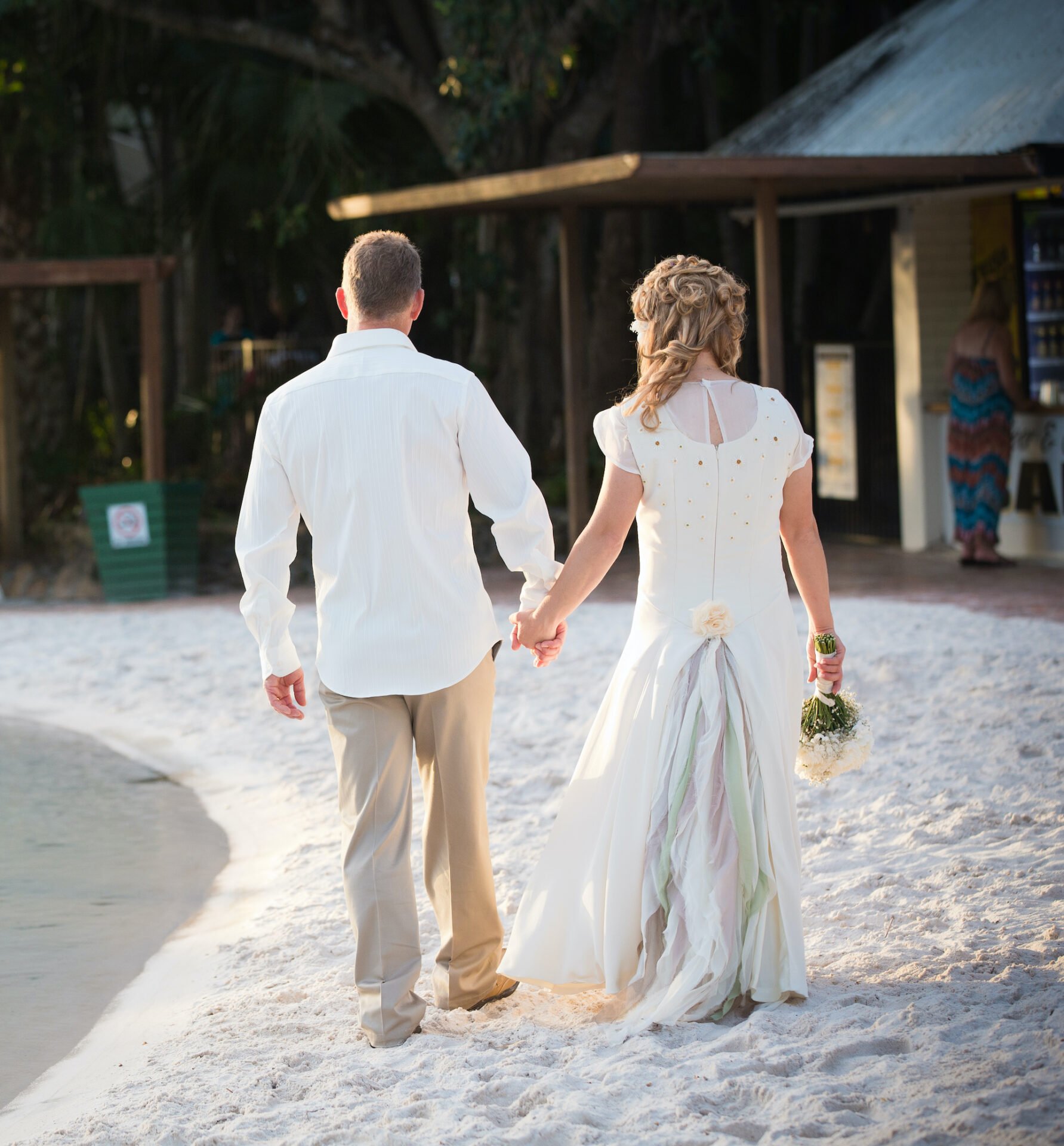 The bride and groom holding hands viewed from behind