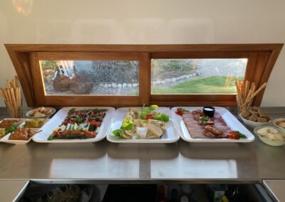 Trays of food on stainless steel counters inside the mobile kitchen.